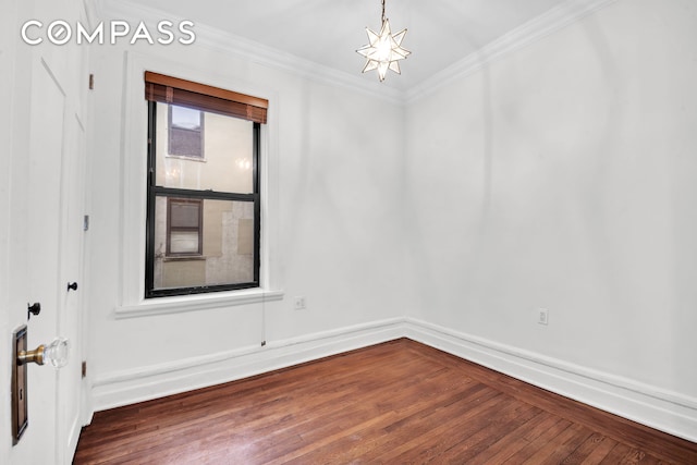 unfurnished room with crown molding, wood finished floors, and a notable chandelier