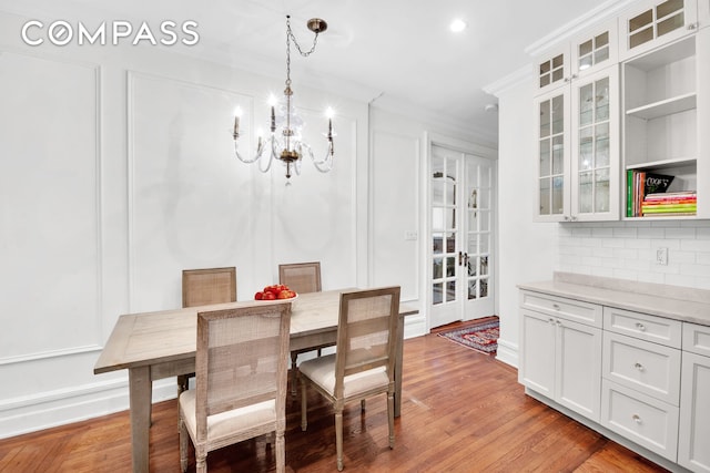 dining area featuring crown molding, recessed lighting, an inviting chandelier, and light wood finished floors