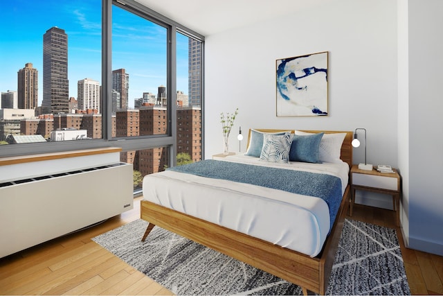 225 W 60th St Unit 14E, New York City, NY 10023 - bedroom with a skyline view and wood-type flooring