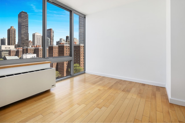 225 W 60th St Unit 14E, New York City, NY 10023 - empty room with a skyline view, wood finished floors, and floor to ceiling windows