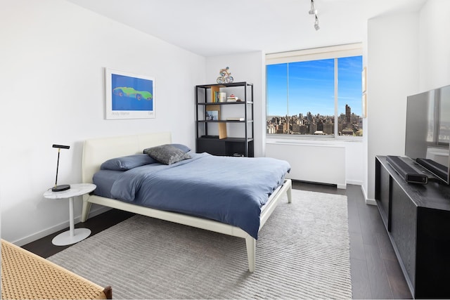 225 W 60th St Unit 14E, New York City, NY 10023 - bedroom with rail lighting and dark wood-style floors
