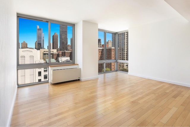 225 W 60th St Unit 14E, New York City, NY 10023 - living area featuring expansive windows, a view of skyline, and wood finished floors