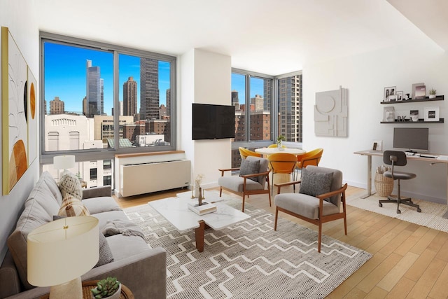 225 W 60th St Unit 14E, New York City, NY 10023 - living room featuring wood finished floors, radiator, and an office area