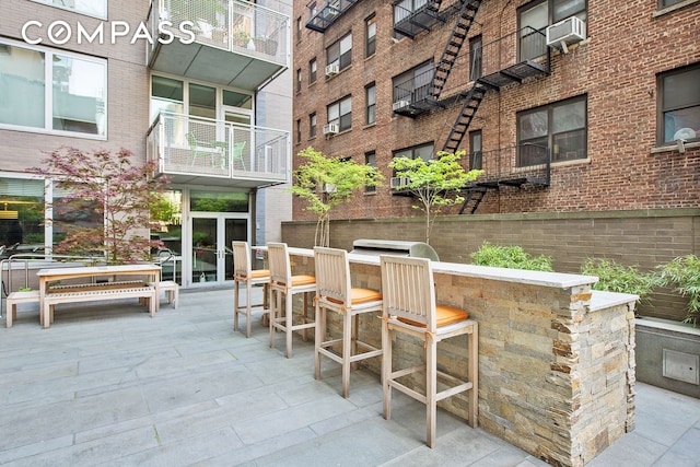 view of patio / terrace featuring outdoor dry bar and cooling unit