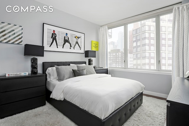 bedroom featuring baseboards and multiple windows