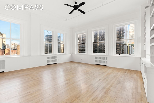 unfurnished sunroom with visible vents and radiator heating unit