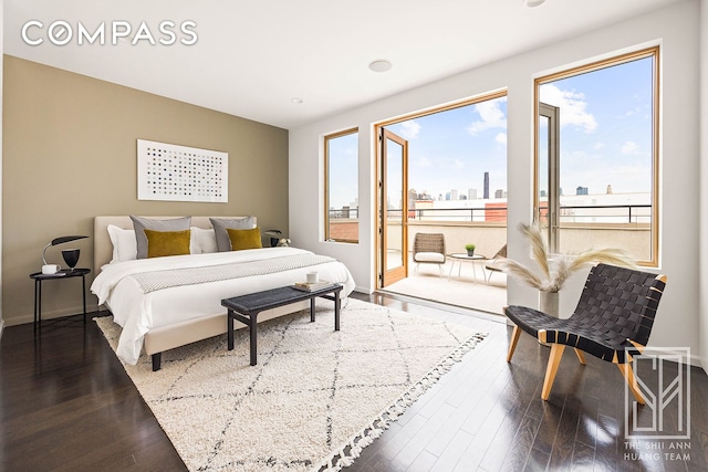 bedroom featuring baseboards, a city view, and dark wood finished floors