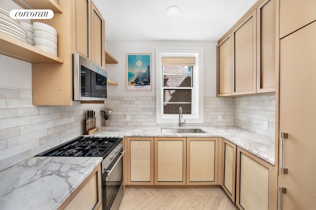 kitchen featuring open shelves, decorative backsplash, light stone counters, a sink, and stainless steel appliances