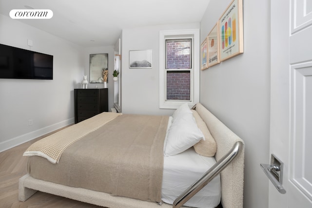 bedroom with baseboards, wood finished floors, and visible vents