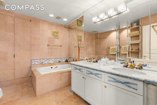 full bathroom with a garden tub, a sink, double vanity, and recessed lighting