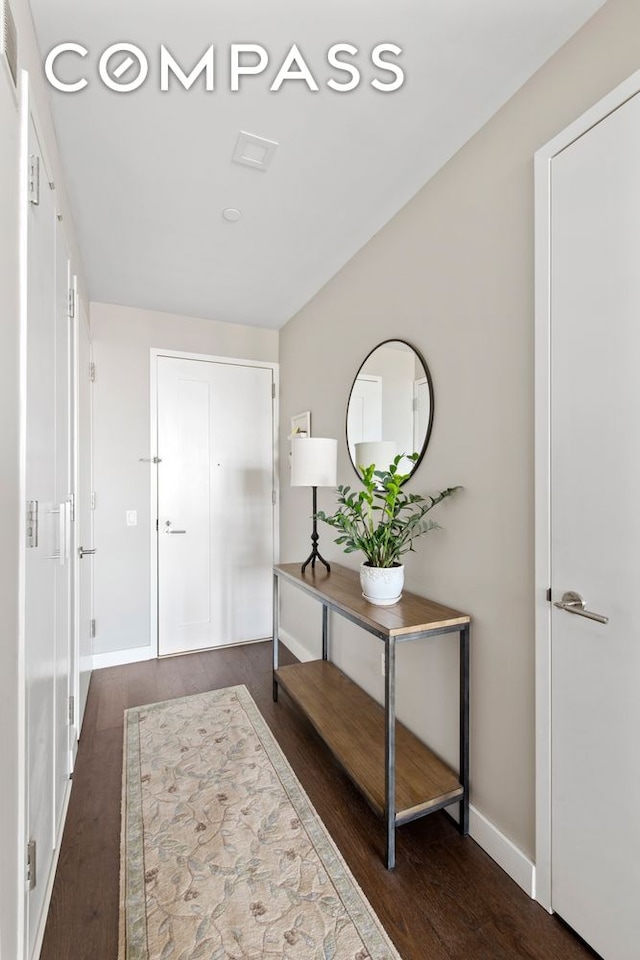 doorway featuring wood finished floors and baseboards