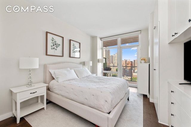 bedroom featuring access to outside, dark wood finished floors, and baseboards