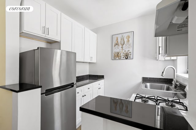 96 Arden St Unit 6K, New York City, NY 10040 - kitchen with freestanding refrigerator, a sink, extractor fan, white cabinets, and dark countertops