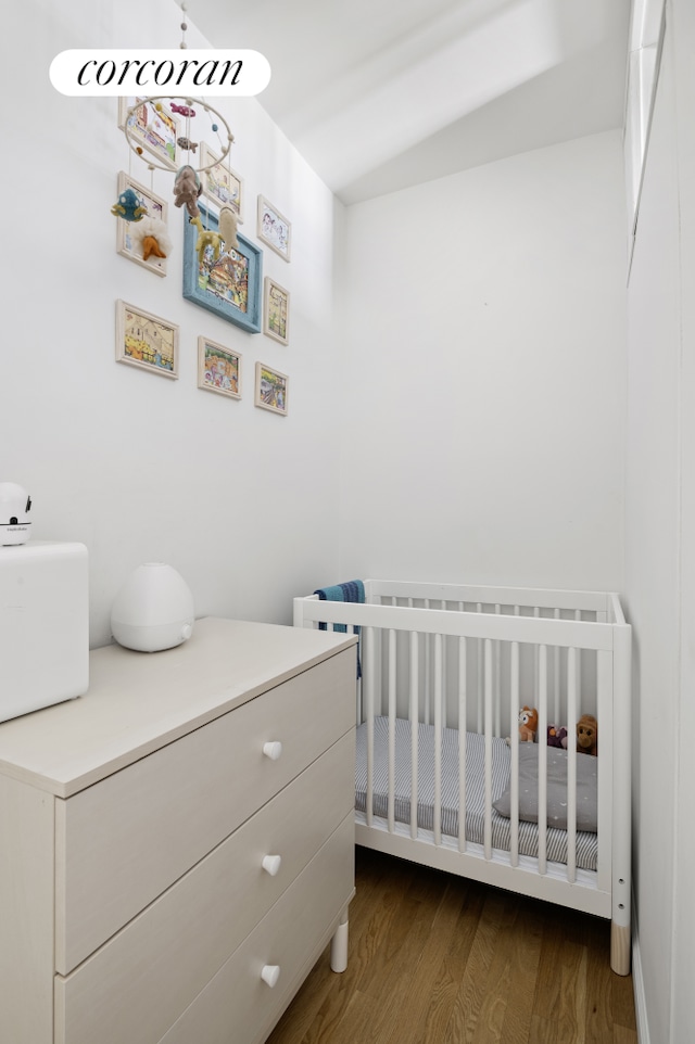 96 Arden St Unit 6K, New York City, NY 10040 - bedroom with dark wood finished floors and a nursery area