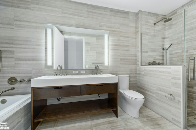 bathroom featuring toilet, a sink, tile walls, and tiled shower
