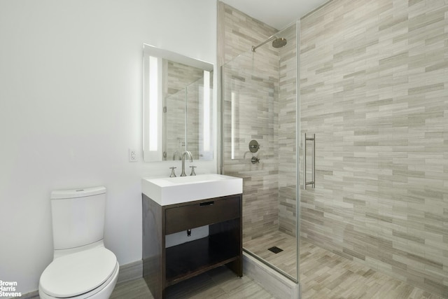 full bathroom featuring vanity, a stall shower, and toilet