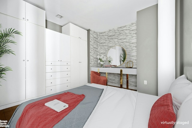 bedroom featuring wood finished floors and visible vents