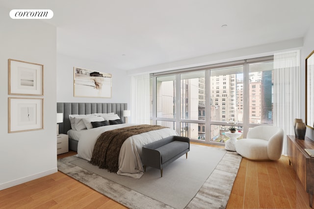bedroom with baseboards, visible vents, and wood finished floors