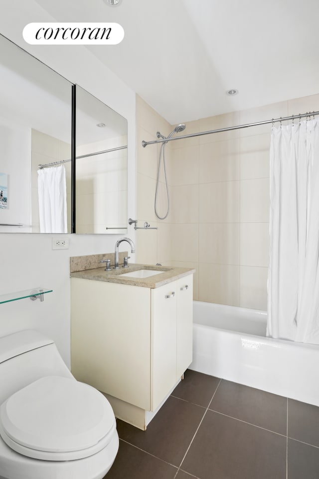 full bathroom with tile patterned floors, shower / bath combo with shower curtain, vanity, and toilet