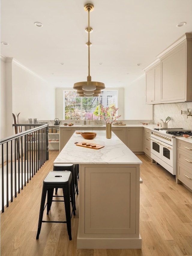 38 Garfield Place, New York City, NY 11215 - kitchen with double oven range, crown molding, backsplash, light wood finished floors, and a kitchen island