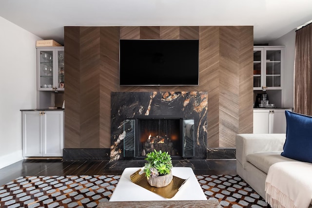 living area featuring dark wood-type flooring and a high end fireplace