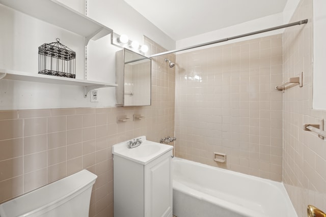 full bathroom with vanity, bathing tub / shower combination, toilet, and tile walls
