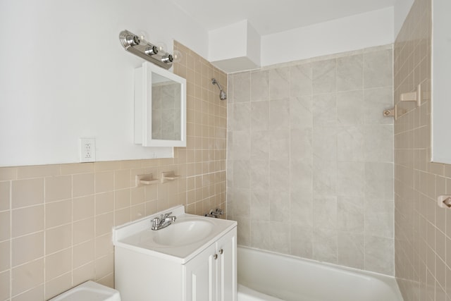 bathroom featuring shower / bath combination, tile walls, and vanity
