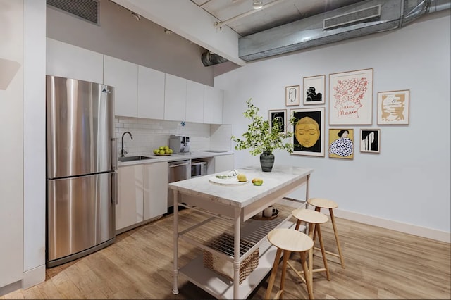 kitchen featuring visible vents, appliances with stainless steel finishes, a sink, light countertops, and white cabinets
