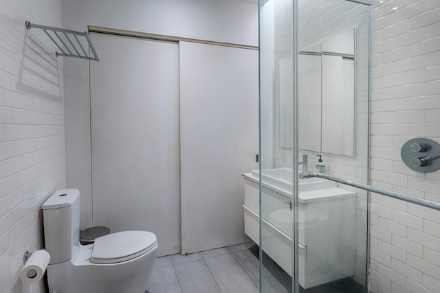 97 Crosby St Unit 1, New York City, NY 10012 - full bathroom with toilet, tile walls, a stall shower, tile patterned flooring, and vanity