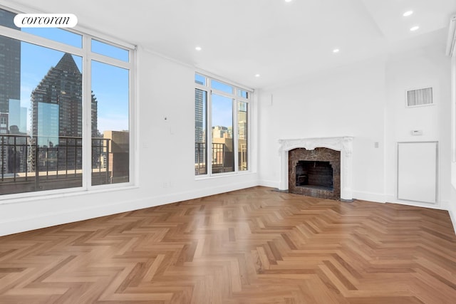 unfurnished living room with baseboards, a view of city, recessed lighting, and a high end fireplace