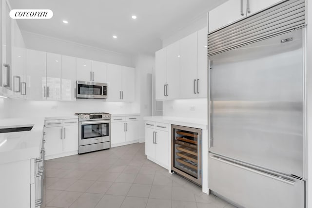 kitchen with wine cooler, recessed lighting, light countertops, white cabinetry, and appliances with stainless steel finishes