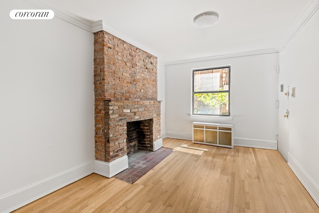 113 W 15th St Unit 1E, New York City, NY 10011 - unfurnished living room with wood-type flooring, radiator, a fireplace, baseboards, and ornamental molding