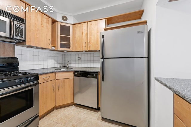 337 E 50th St Ph-E, Ph-E New York City, NY 10022 - kitchen with appliances with stainless steel finishes, backsplash, glass insert cabinets, light tile patterned floors, and light brown cabinetry