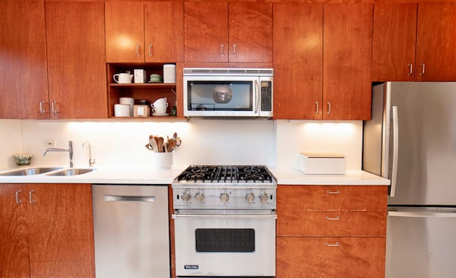 kitchen featuring appliances with stainless steel finishes, open shelves, brown cabinets, a sink, and light countertops