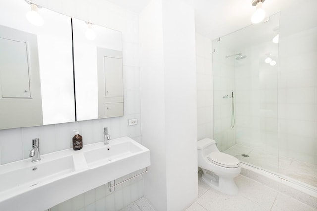 bathroom featuring a sink, speckled floor, toilet, and tiled shower