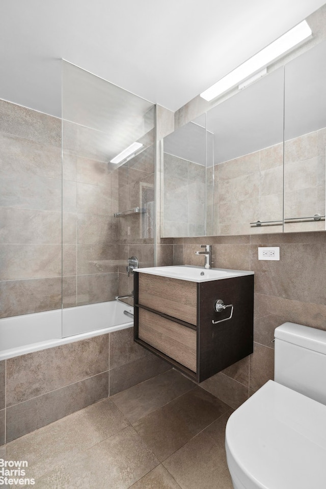 60 Sutton Pl S Unit 3Kn, New York City, NY 10022 - bathroom featuring tile walls, vanity, tiled shower / bath combo, and toilet