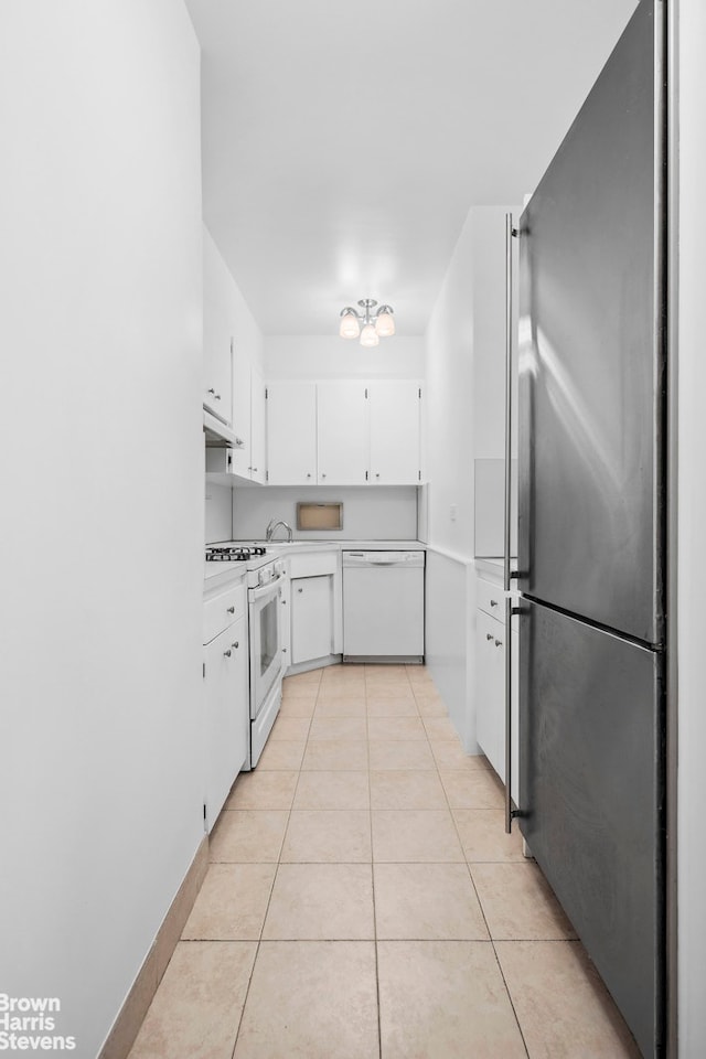 60 Sutton Pl S Unit 3Kn, New York City, NY 10022 - kitchen with white appliances, light countertops, white cabinets, light tile patterned flooring, and under cabinet range hood