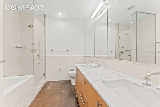 545 W 110th St Unit 5A, New York City, NY 10025 - full bath featuring tile walls, a shower stall, toilet, double vanity, and tiled bath