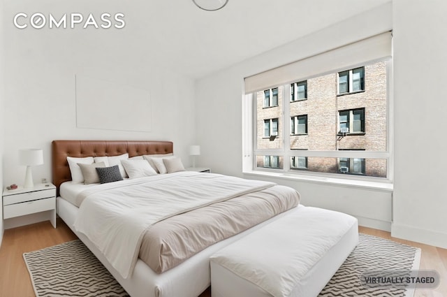 bedroom with light wood-style floors and baseboards
