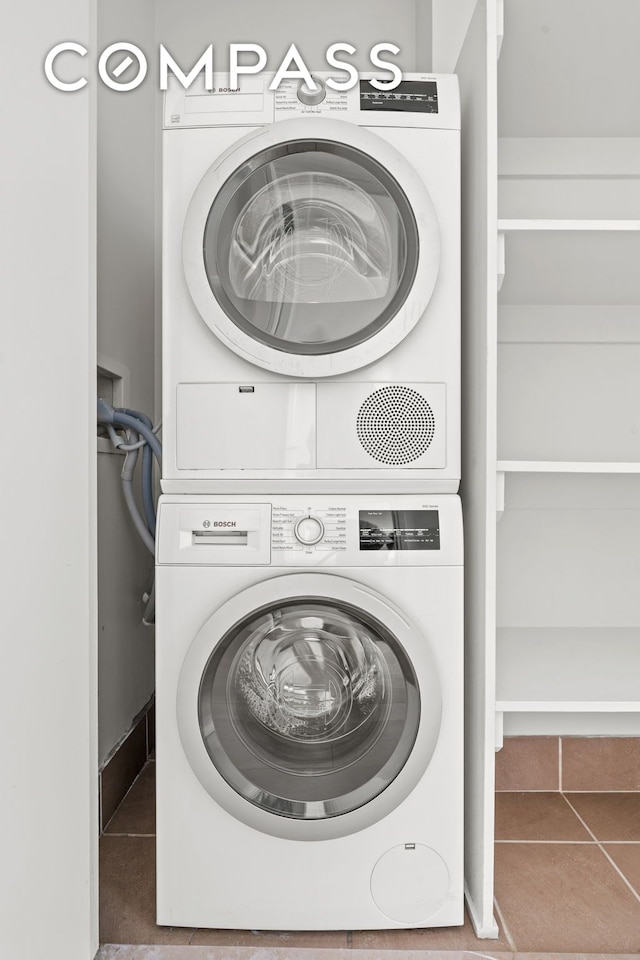 laundry area featuring tile patterned flooring, stacked washer / drying machine, and laundry area