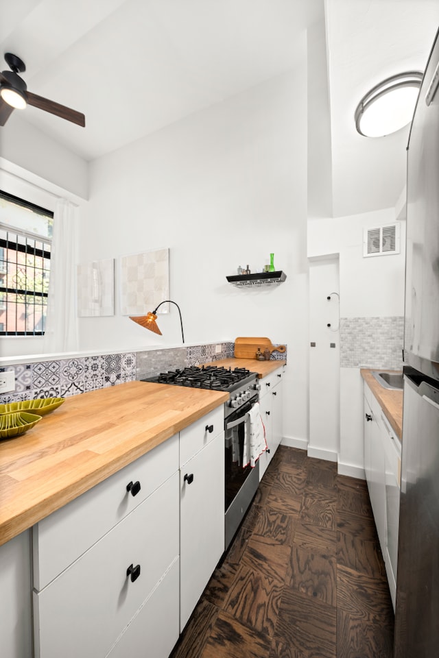 350 E 62nd St Unit 1J, New York City, NY 10065 - kitchen with gas stove, wood counters, ceiling fan, and white cabinets