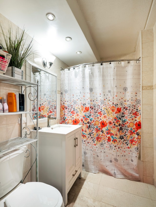 full bath featuring recessed lighting, vanity, toilet, and tile walls
