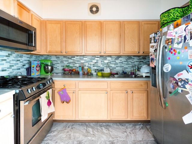 kitchen featuring visible vents, a sink, decorative backsplash, and stainless steel appliances