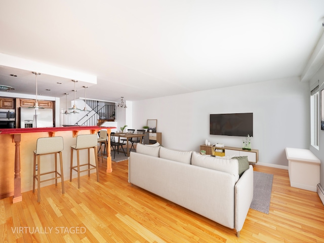 living area with baseboards and light wood finished floors