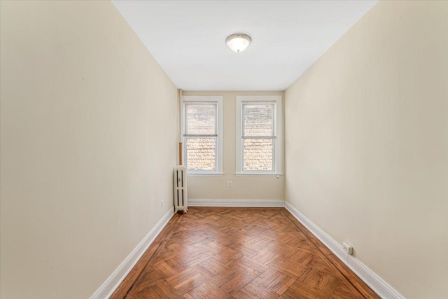 empty room featuring baseboards and radiator heating unit