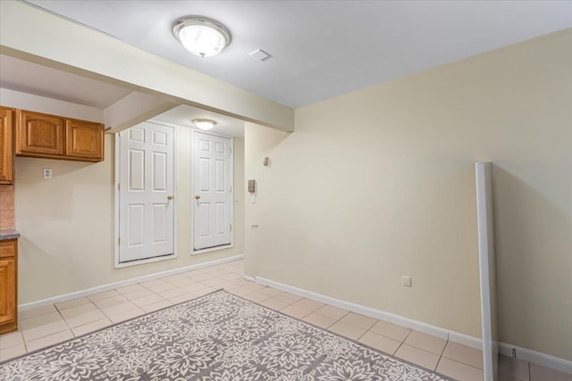 spare room with light tile patterned floors and baseboards