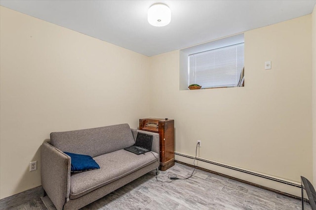 sitting room featuring baseboards, baseboard heating, and wood finished floors