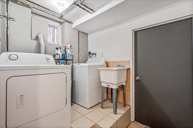 laundry area with separate washer and dryer, laundry area, a sink, and light tile patterned flooring
