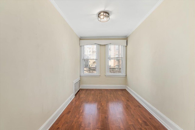 unfurnished room featuring crown molding, baseboards, and wood finished floors