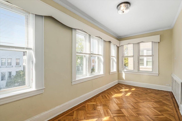 spare room featuring baseboards, ornamental molding, and a healthy amount of sunlight